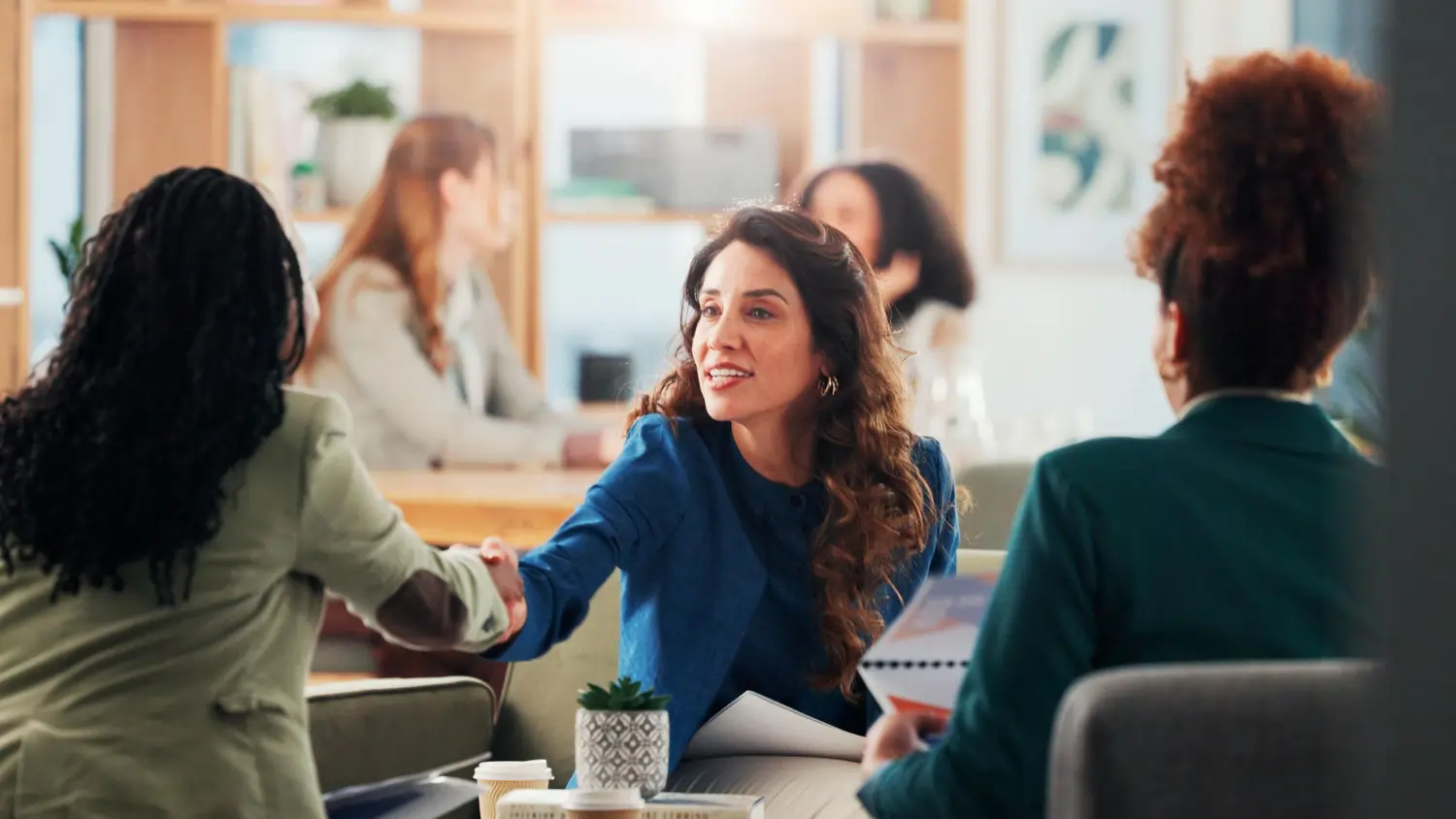 Women in professional office setting discussing hiring – best background screening companies for employers USA